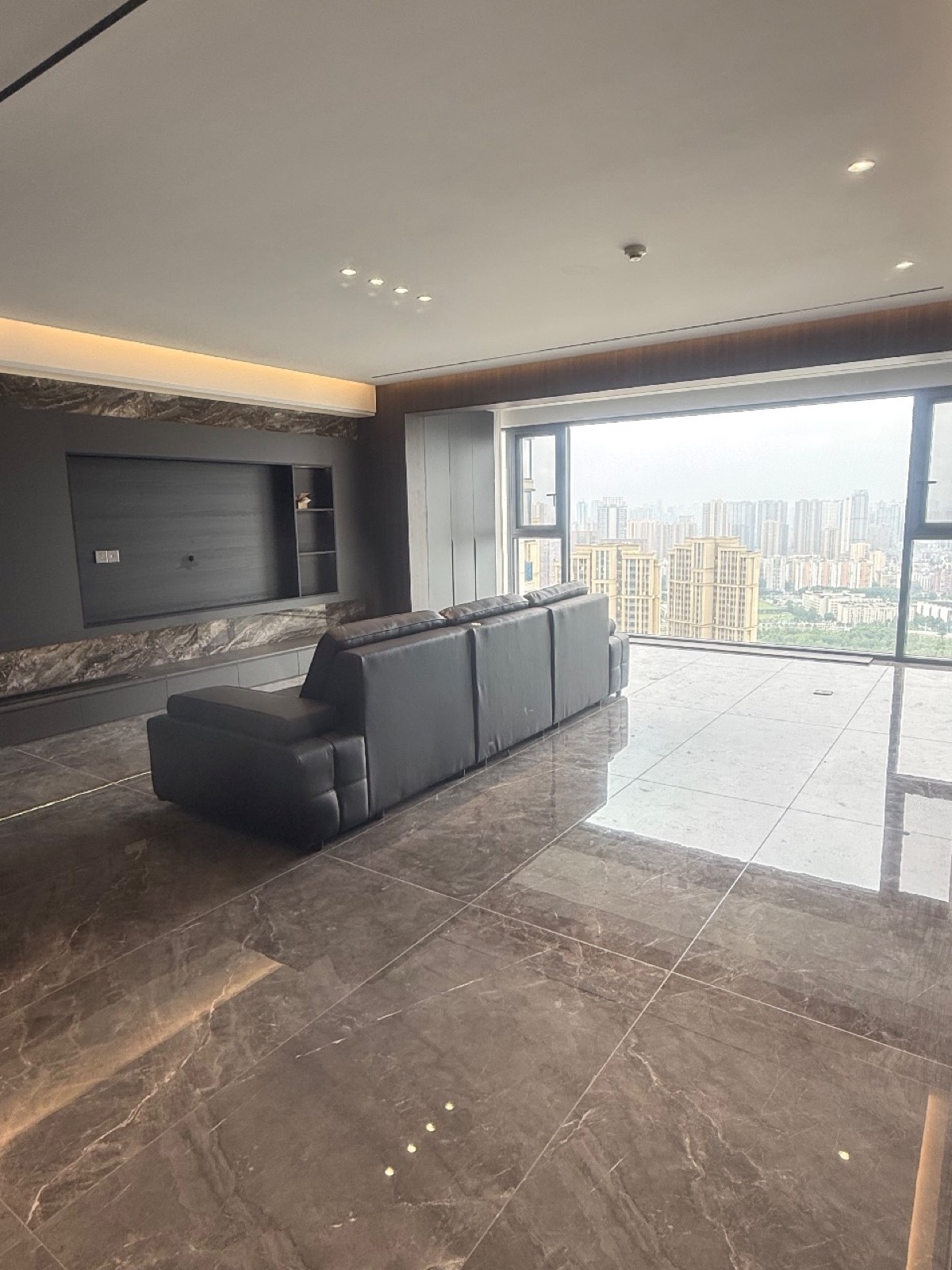 硚口138㎡客厅全景，灰棕石纹地面与深色沙发